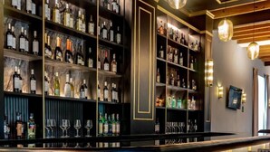 A bar area with shelves of bottles and glasses, a curved counter, and bar stools. - Hotel Ex hacienda Chautla Puebla, Trademark by Wyndham (San Salvador el Verde)