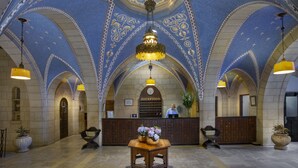 A lobby with a reception desk, a chandelier, and a patterned ceiling. - YMCA Three Arches Hotel (Jerusalem)