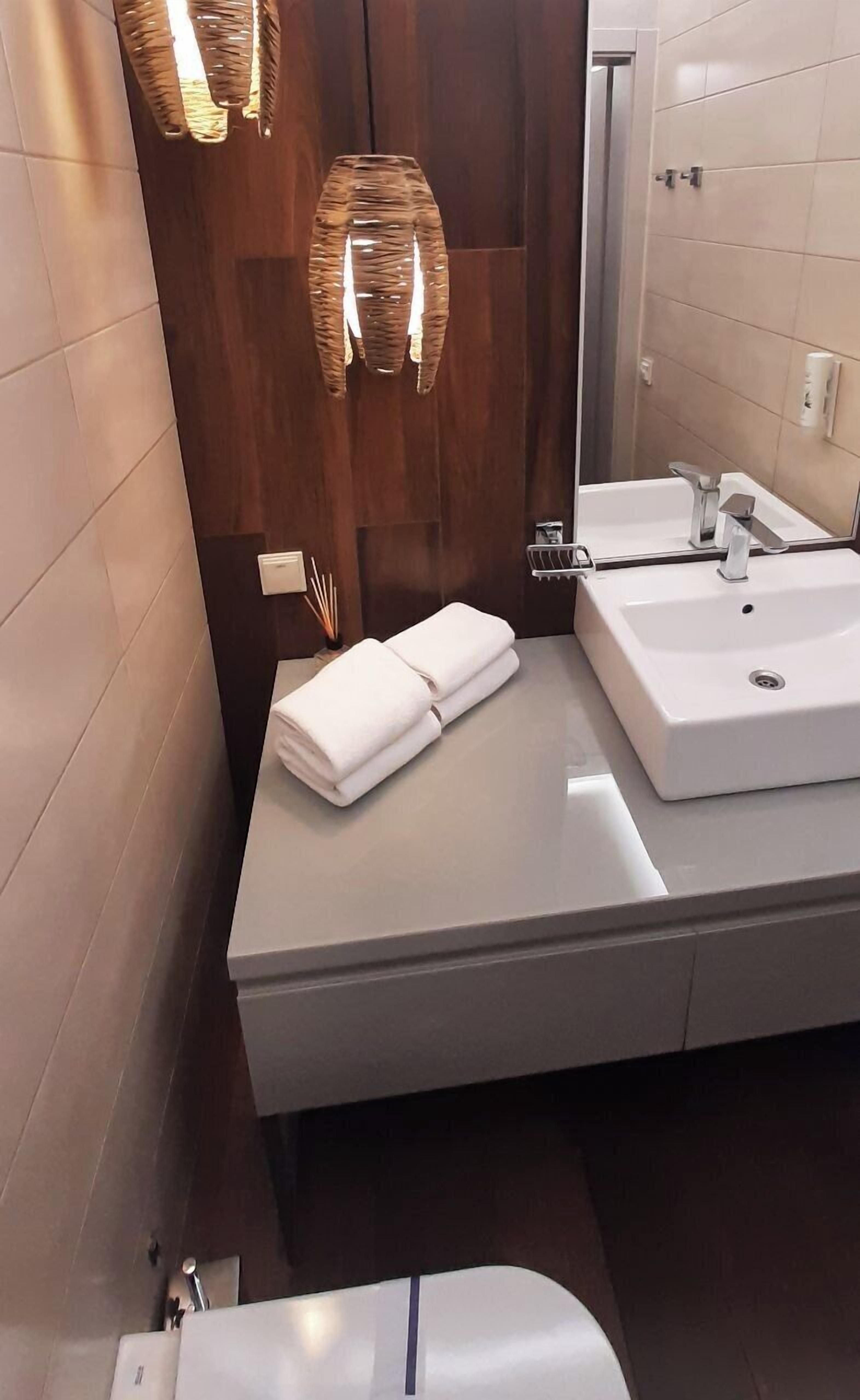 Um banheiro moderno com um espelho grande, duas pias e um porta-toalhas.