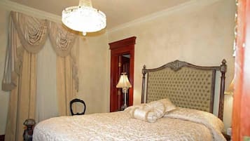 Un dormitorio con una cama grande, una araña y cortinas.