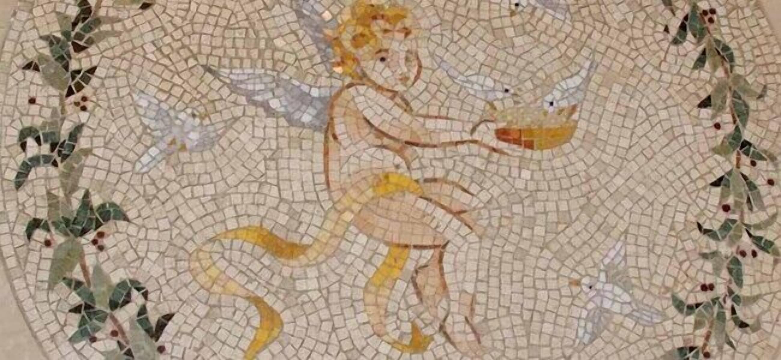 Une mosaïque représentant une figure tenant une coupe, entourée de feuillage.