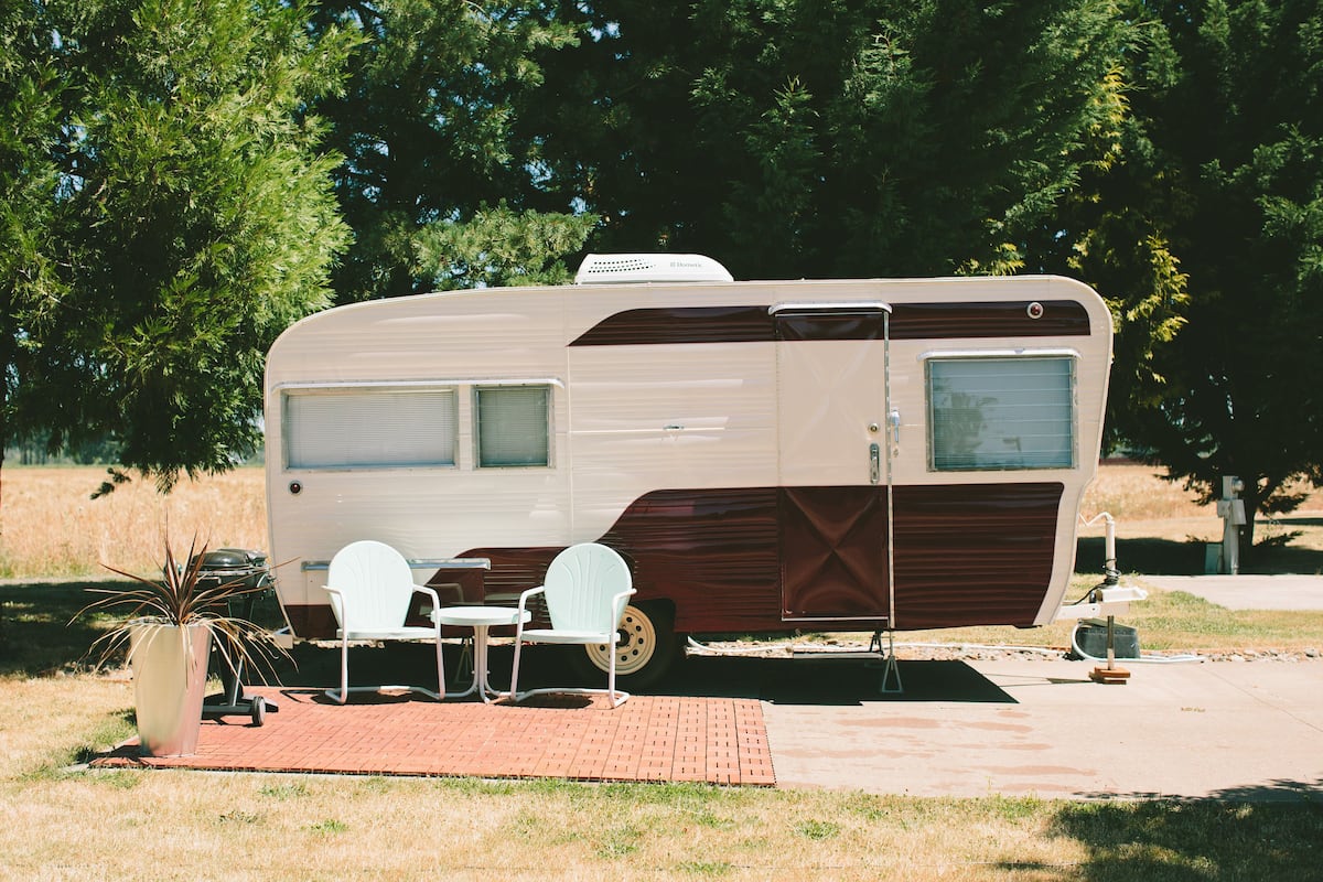A recreational vehicle with a dining area, two chairs, and a small table.