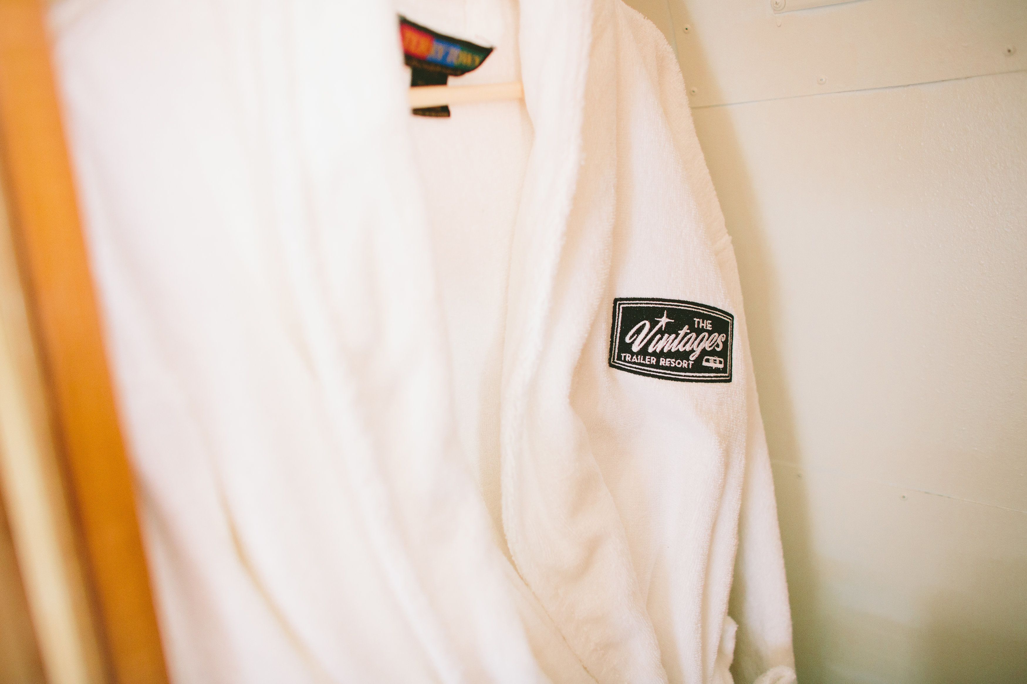 A white robe with a patch that reads "Vintage Trailer Resort."