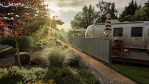 Jardim bem cuidado com diversas plantas e um deck de madeira.