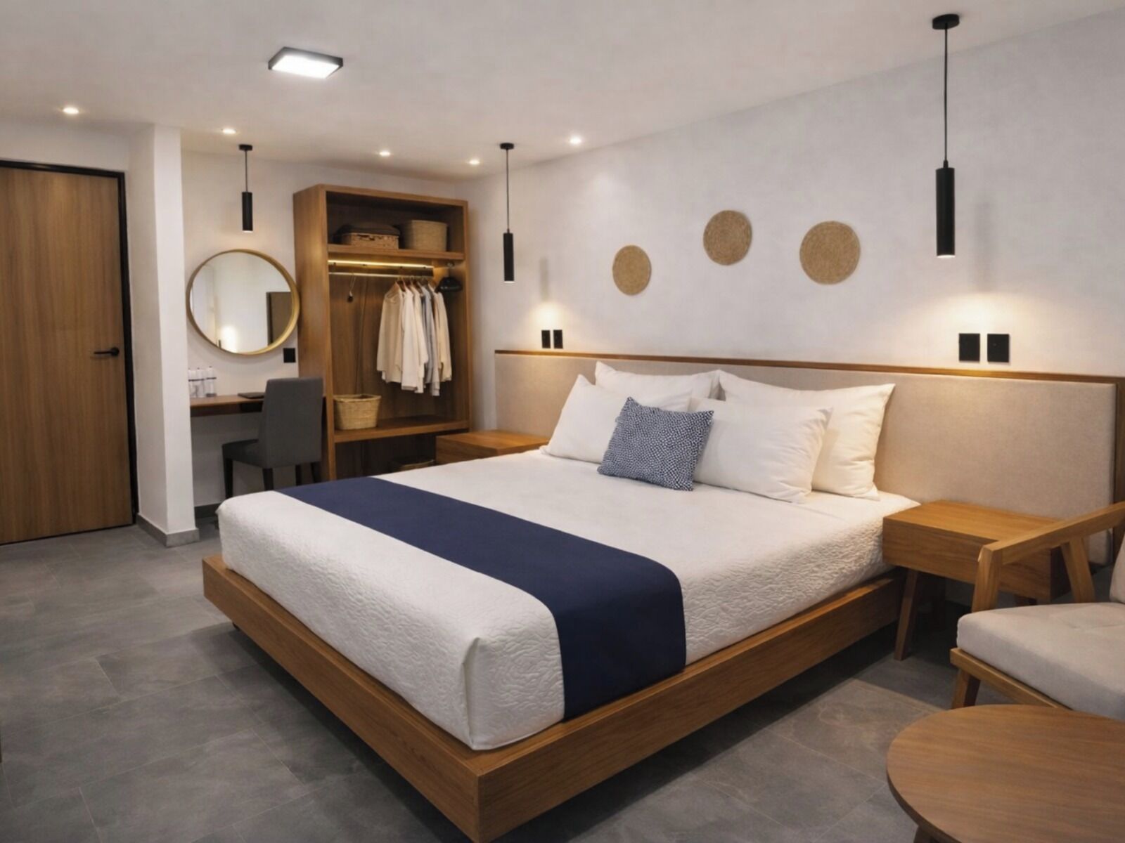 Un dormitorio moderno con una cama grande, un armario de madera, un escritorio y un espejo redondo.