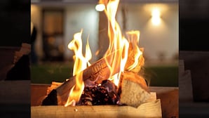 A fire burning in a fireplace with logs and a visible chimney. - Hotel Ix by San Clemente Business Class (Tlaxcala)