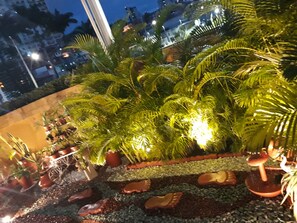 Un jardín en la azotea con macetas y elementos decorativos.