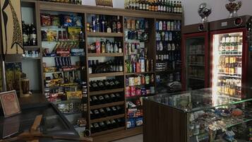 A liquor store with shelves stocked with various alcoholic beverages, snacks, and toiletries.