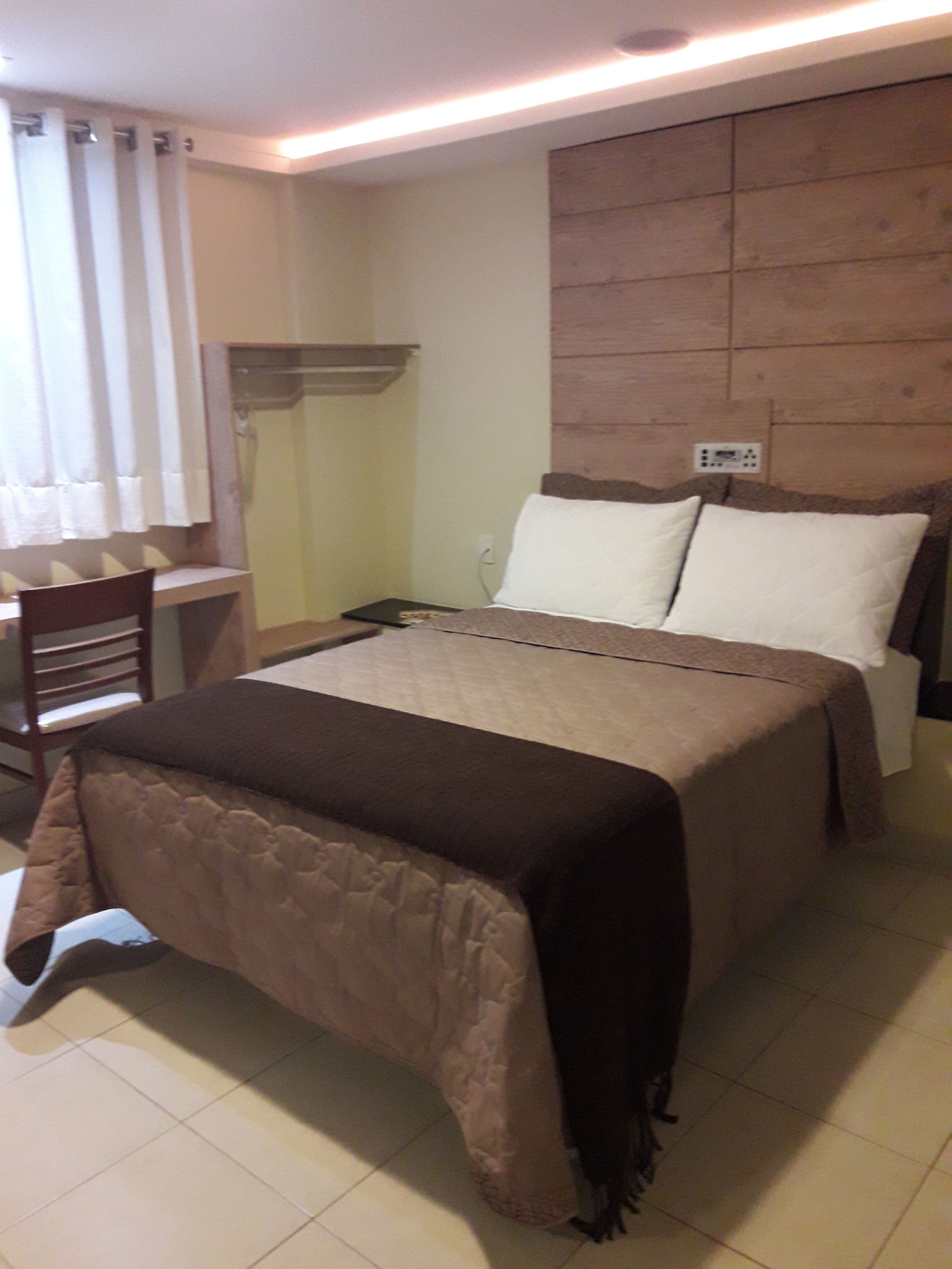 Ein Hotelzimmer mit Bett, Schreibtisch und Stuhl.