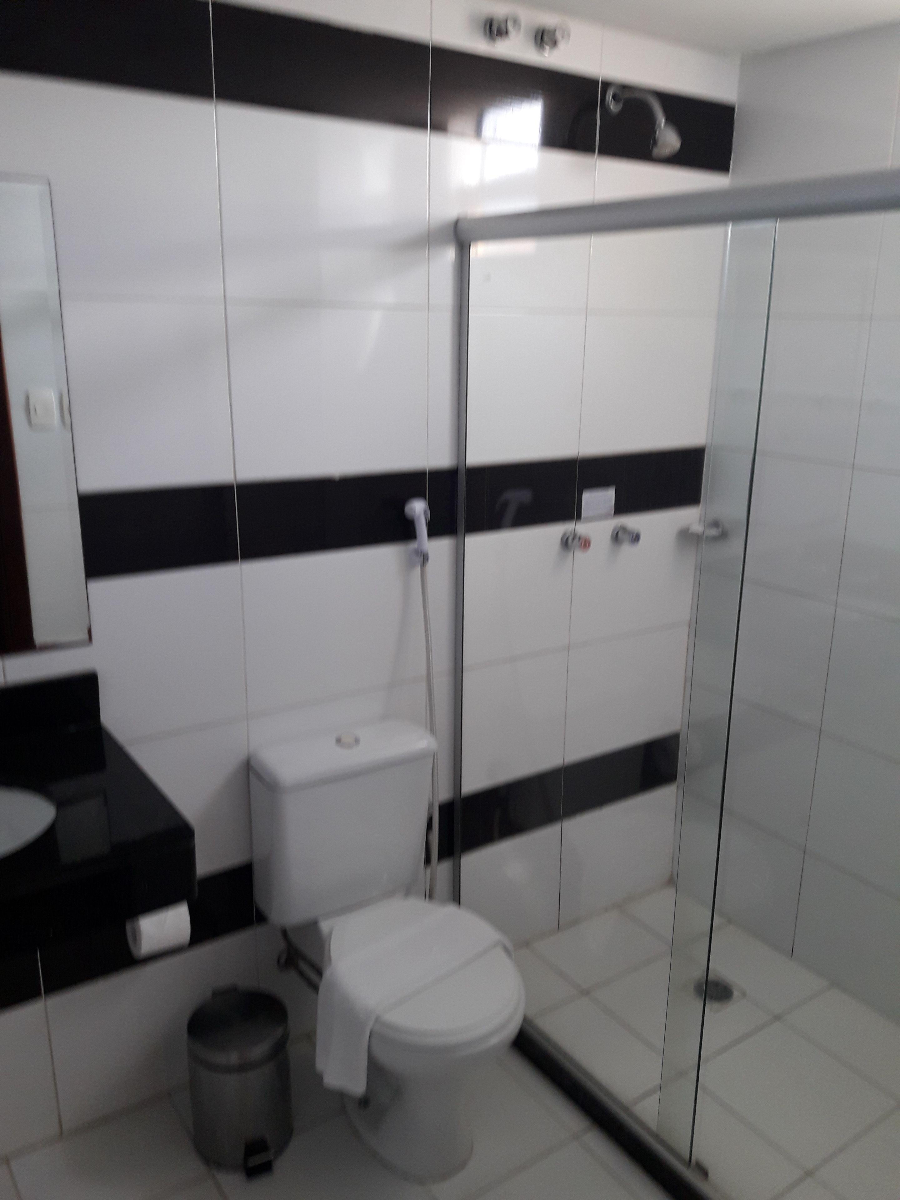 Un baño con inodoro, lavabo y zona de ducha.