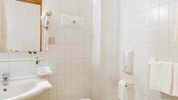 Une salle de bain équipée d’un lavabo, de toilettes, d’un bidet et d’un miroir.