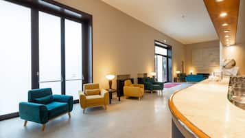 A spacious lobby with a reception desk, several seating areas, and large windows allowing natural light.