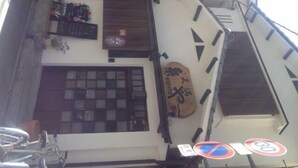 A narrow alley with a bicycle parked on the left, a wooden door, and a window with a grid pattern. - Tenma Itoya Guest House - Hostel (Osaka)