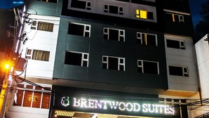 Een meerhoog gebouw met een bordje dat "BRENTWOOD SUITES" vermeldt.