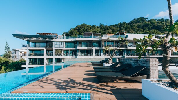 A modern hotel with a rooftop pool, multiple balconies, and lush greenery in the background. - The Unity & The Bliss Patong Residence (Patong)