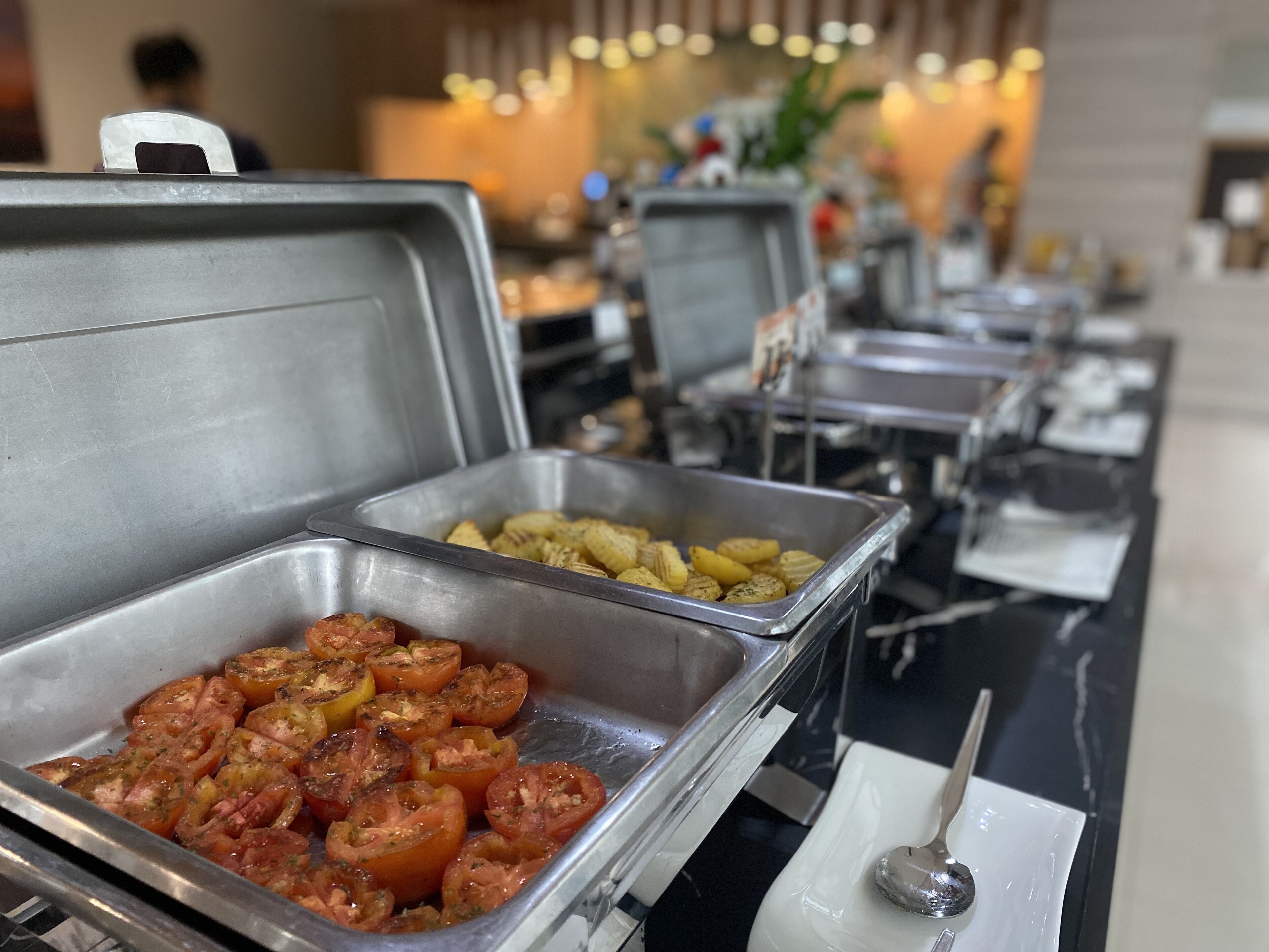 Un buffet proposant une variété de plats, notamment des tomates et des pommes de terre rôties.