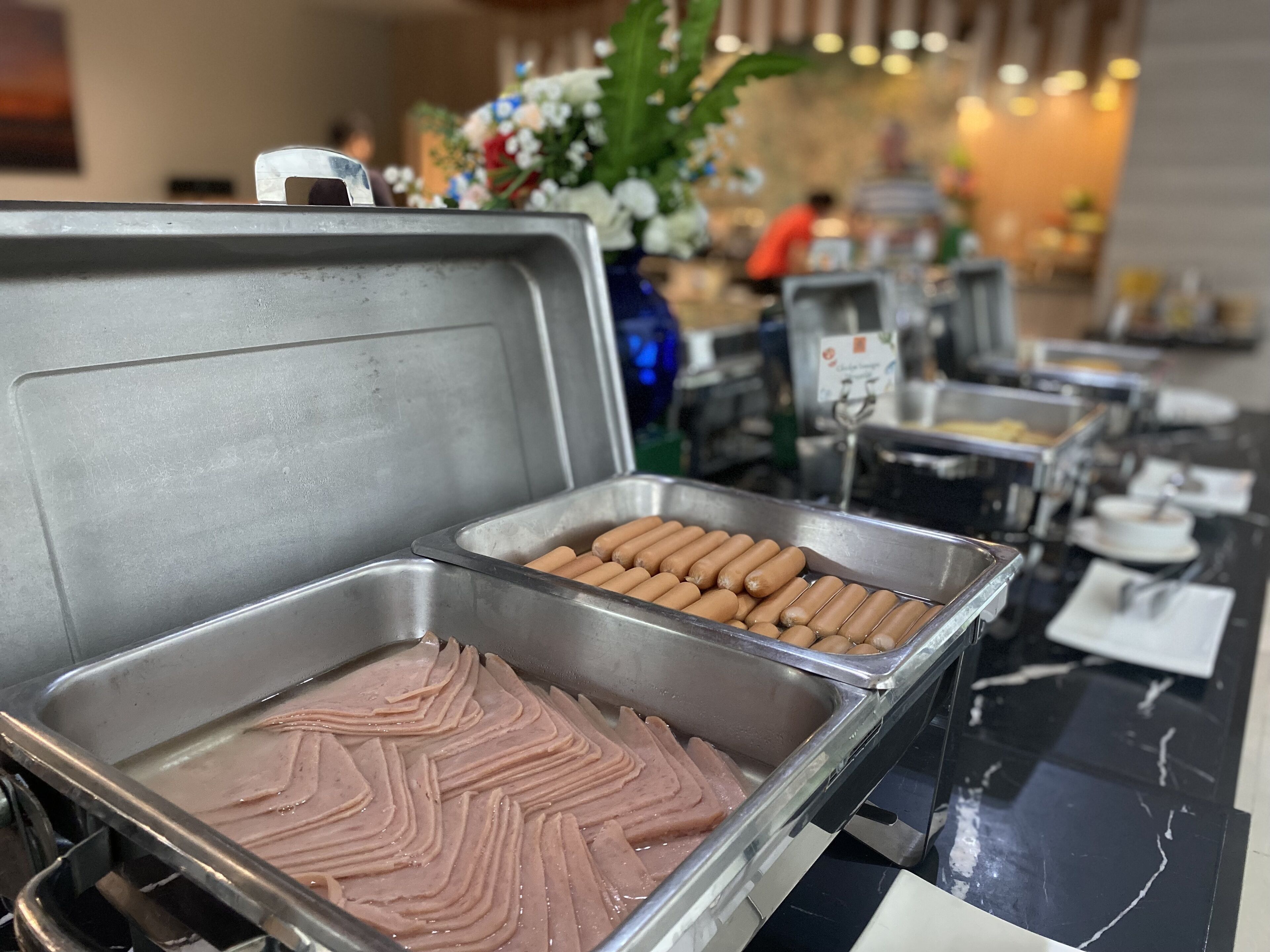 Ein Buffet mit Platten voller Aufschnitt und Hot Dogs.