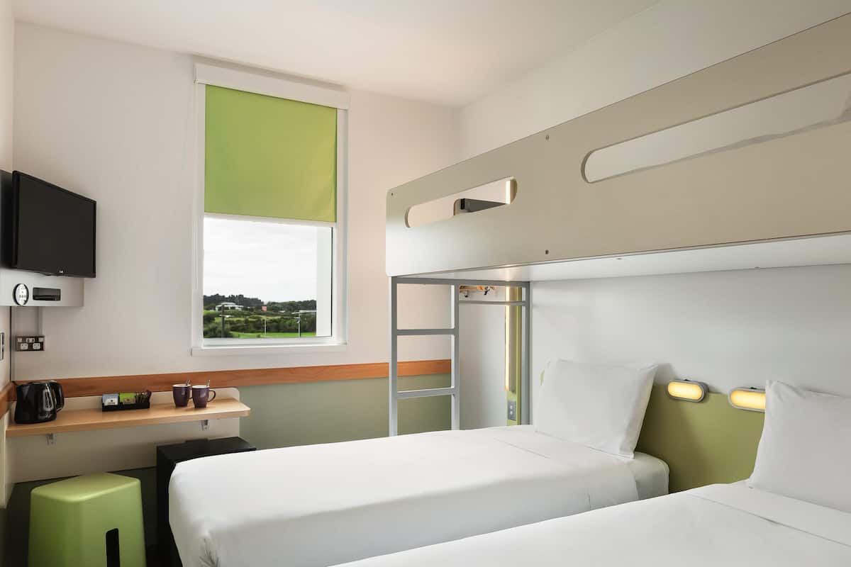 Escritorio, cortinas blackout y tabla de planchar con plancha