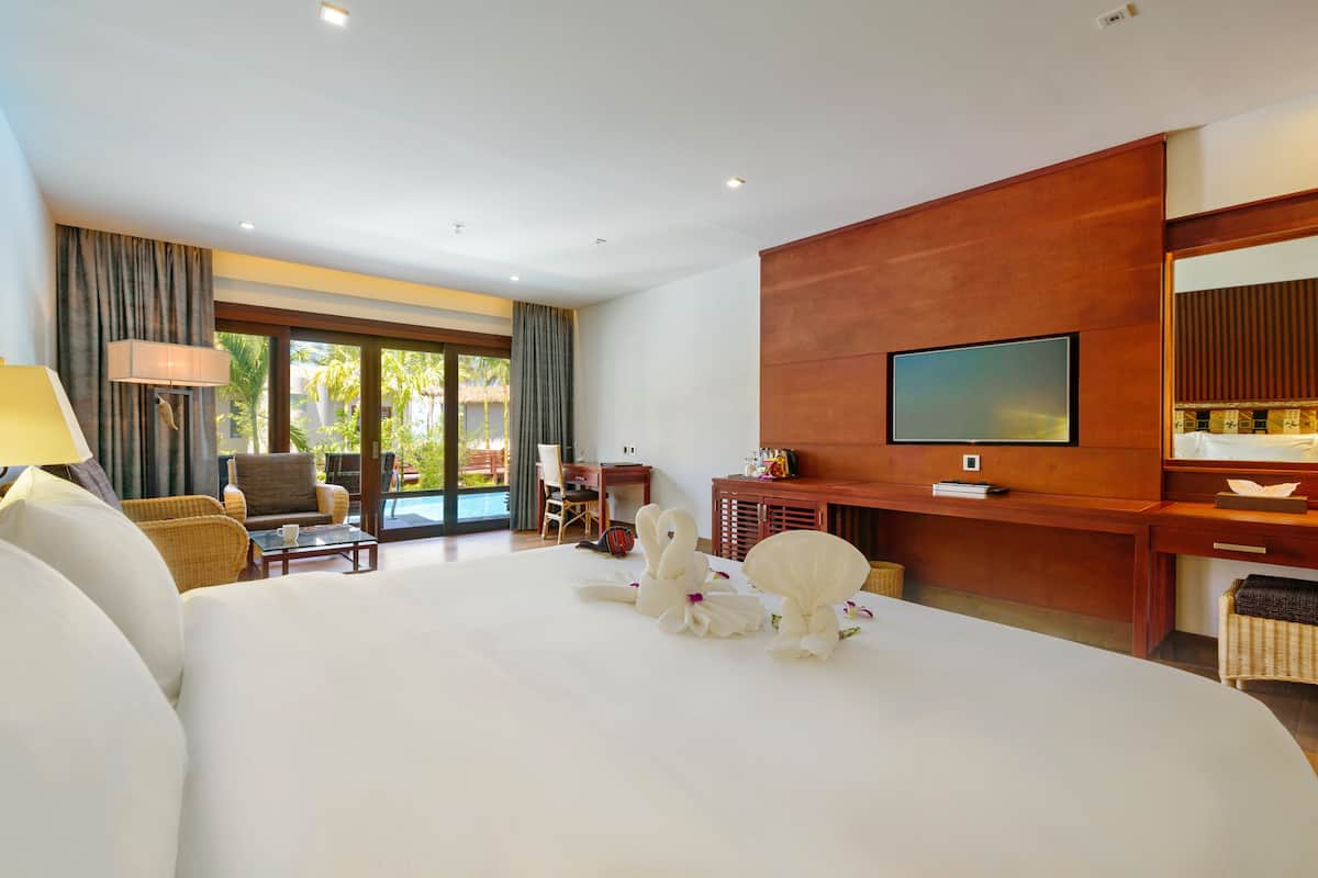 Een hotelkamer met een groot bed, een televisie, een bureau en uitzicht op de omgeving.