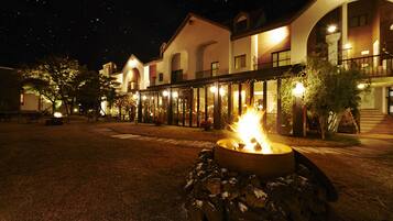 A hotel with a fire pit in the courtyard, outdoor seating, and a covered patio area.