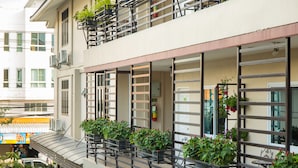A multi-story building with balconies, outdoor seating, and potted plants. - Chiang Mai Waroros Boutique Hotel (Chiang Mai)