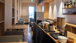 A modern hotel lobby with a long reception desk, seating area, and a coffee station. - APA Hotel Higashi Shinjuku Kabukicho (Tokyo)