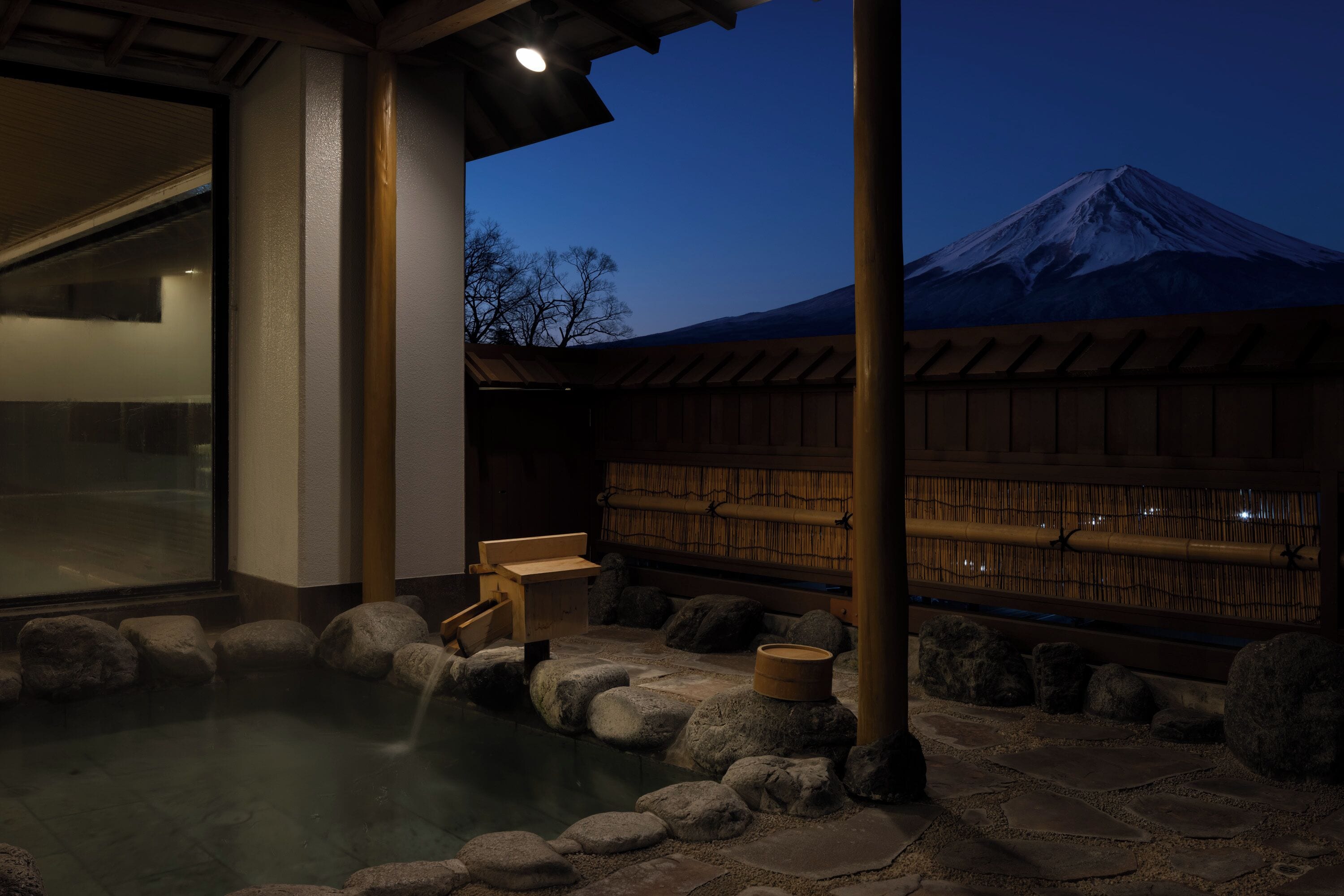 A traditional Japanese onsen with a view of Mount Fuji in the background.