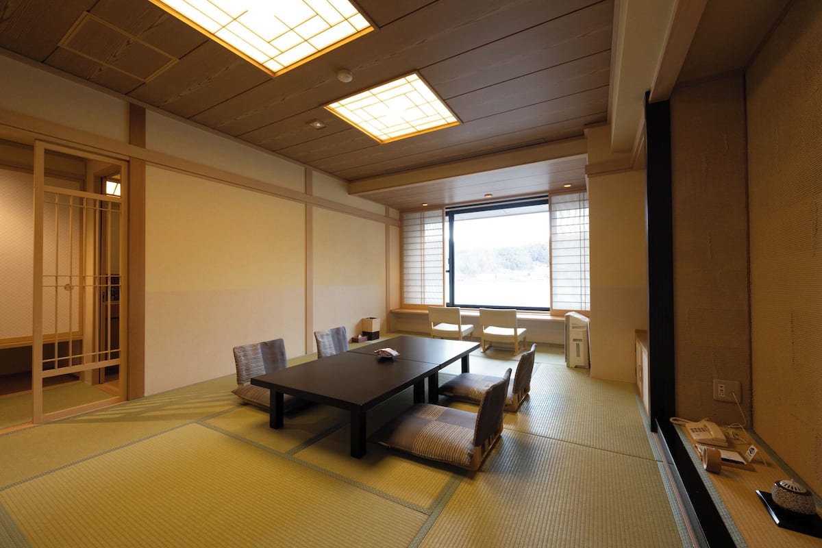 Une pièce de style japonais traditionnel, avec un sol recouvert de tatamis, une table basse et des portes coulissantes.