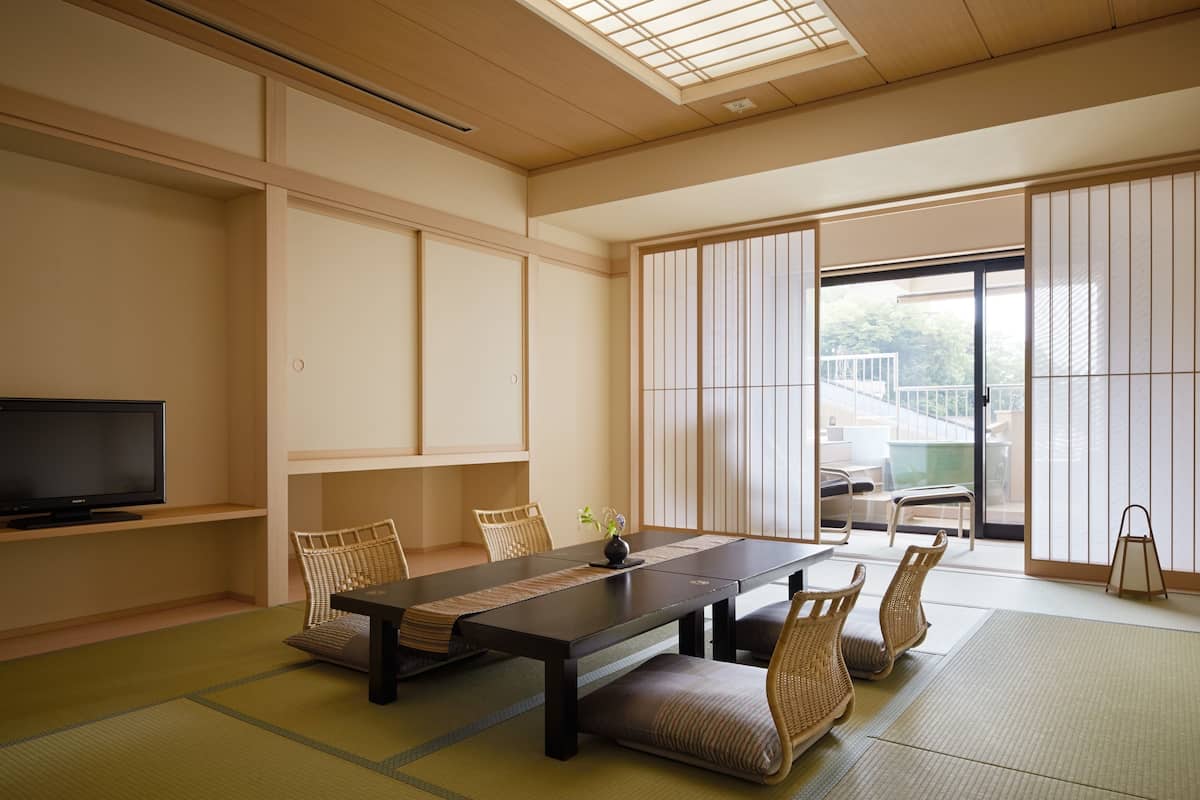 Une pièce de style japonais traditionnel, avec un sol recouvert de tatamis, une table basse et des paravents en papier de riz (shoji).