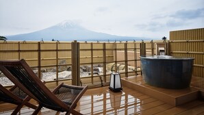 A wooden deck with a hot tub and lounge chairs, overlooking a mountain. - Konansou (Fujikawaguchiko)