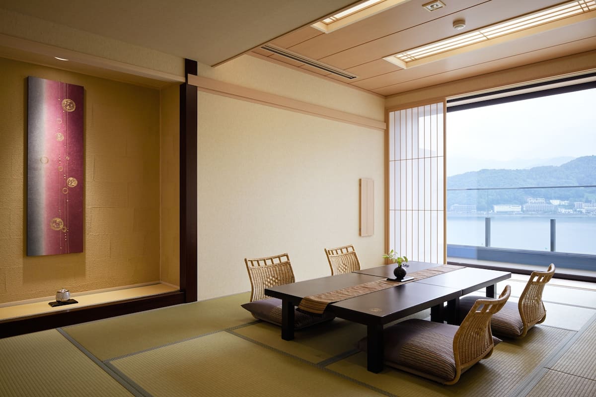 Une pièce de style japonais traditionnel, avec un sol recouvert de tatamis, une table basse et des paravents en papier.
