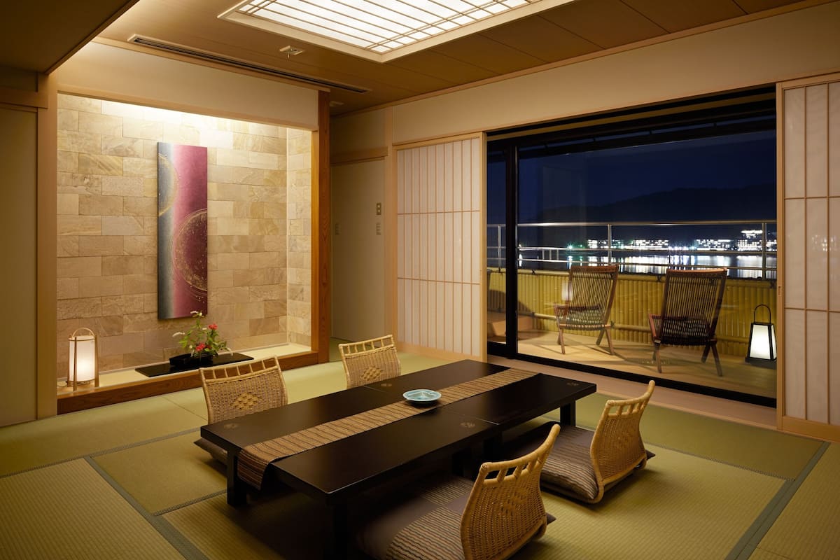 Une pièce de style japonais traditionnel, avec un sol recouvert de tatamis, une table basse et des paravents en papier de riz (shoji).