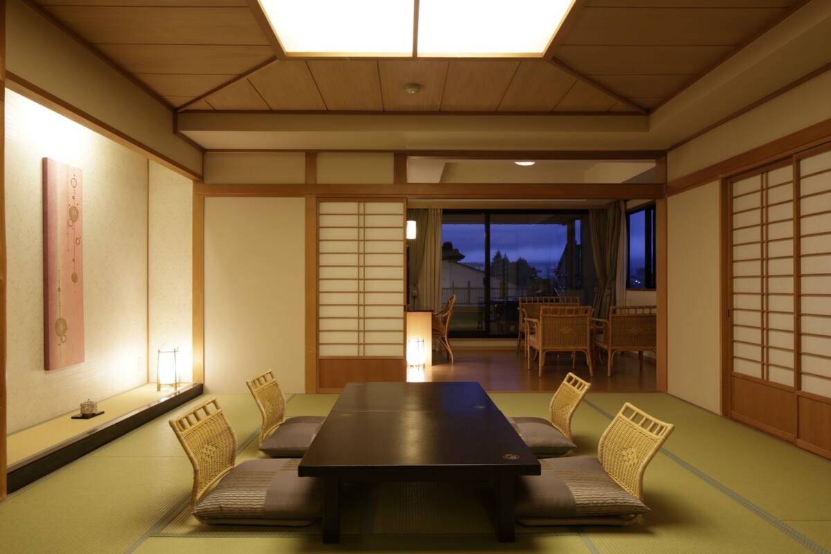 Une pièce de style japonais traditionnel, avec un sol recouvert de tatamis, une table basse et des paravents en papier.