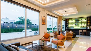 A modern hotel lobby with large windows, a bar area, and seating arrangements.