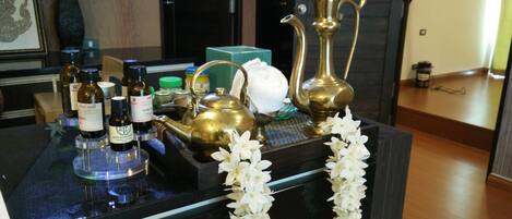 A reception desk with essential amenities including a tea set, bottles of essential oils, and a decorative garland.
