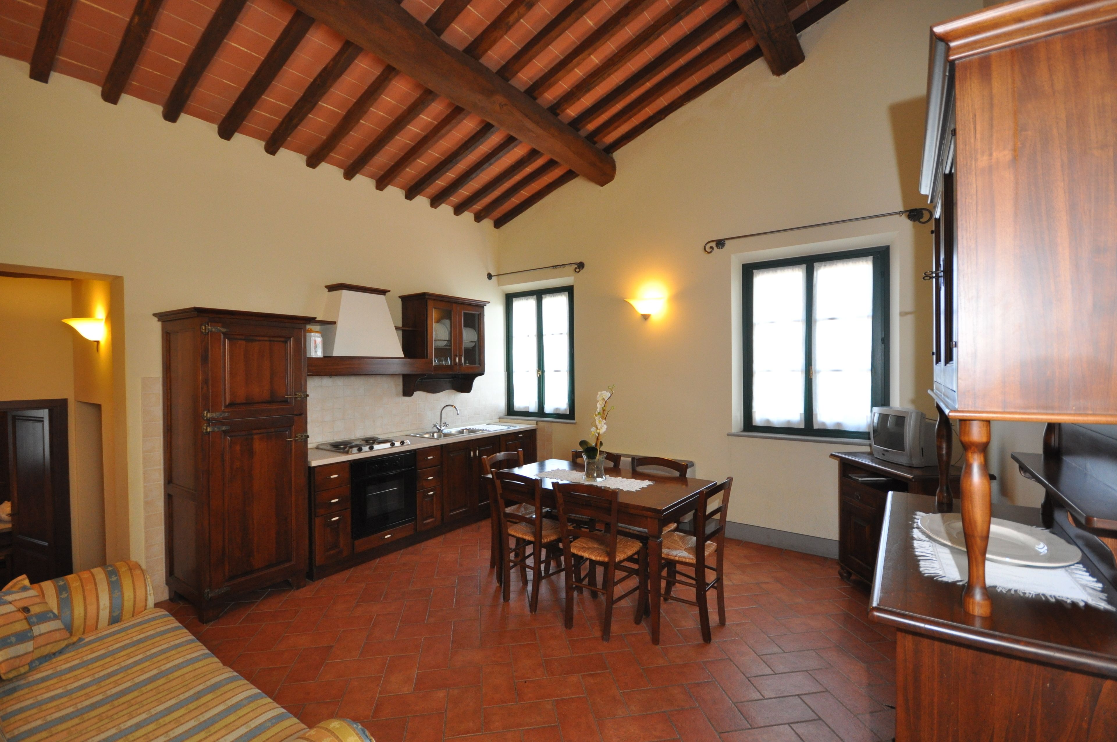 A spacious kitchen with wooden cabinets, a dining table, and chairs.