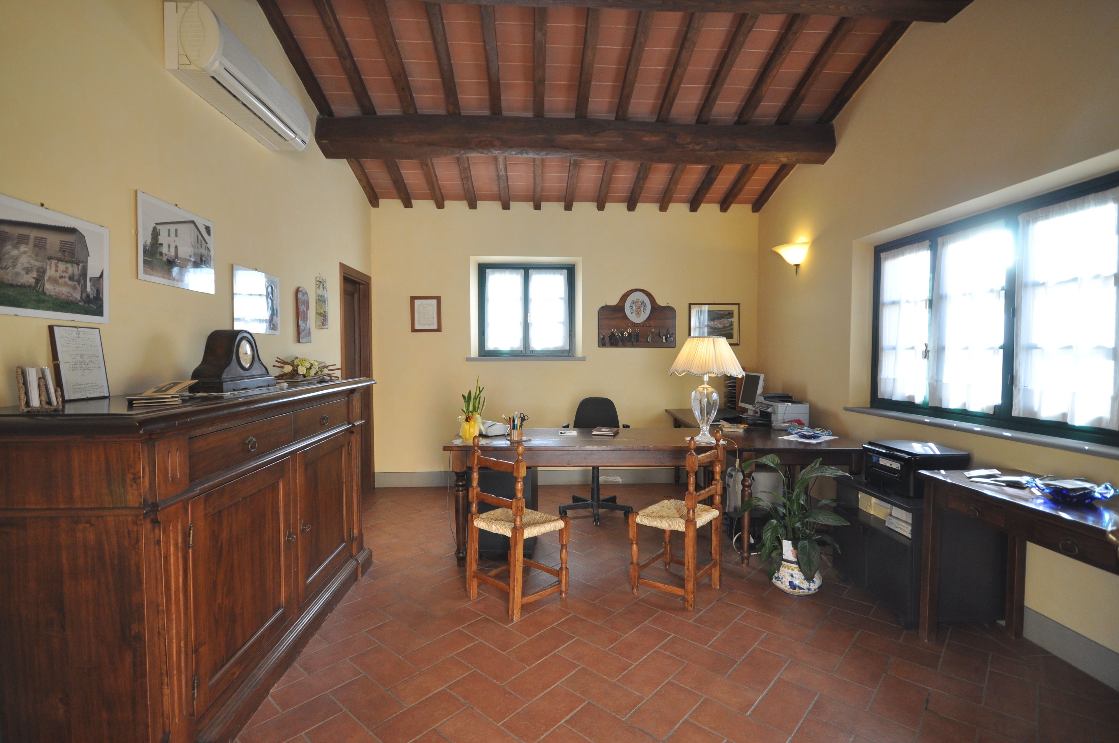 Un comedor con mesa y sillas de madera, una encimera de cocina y un ventanal con cortinas.