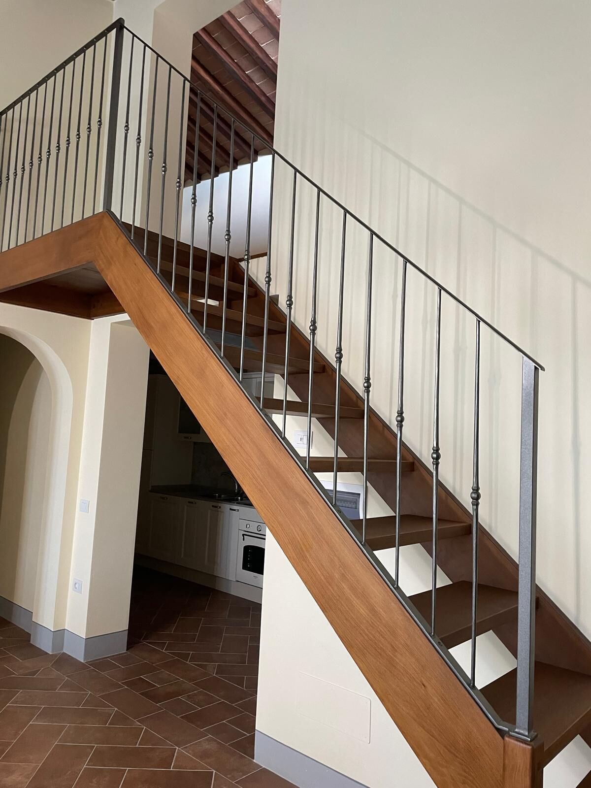 A staircase with wooden steps and metal railings, leading to an upper floor.