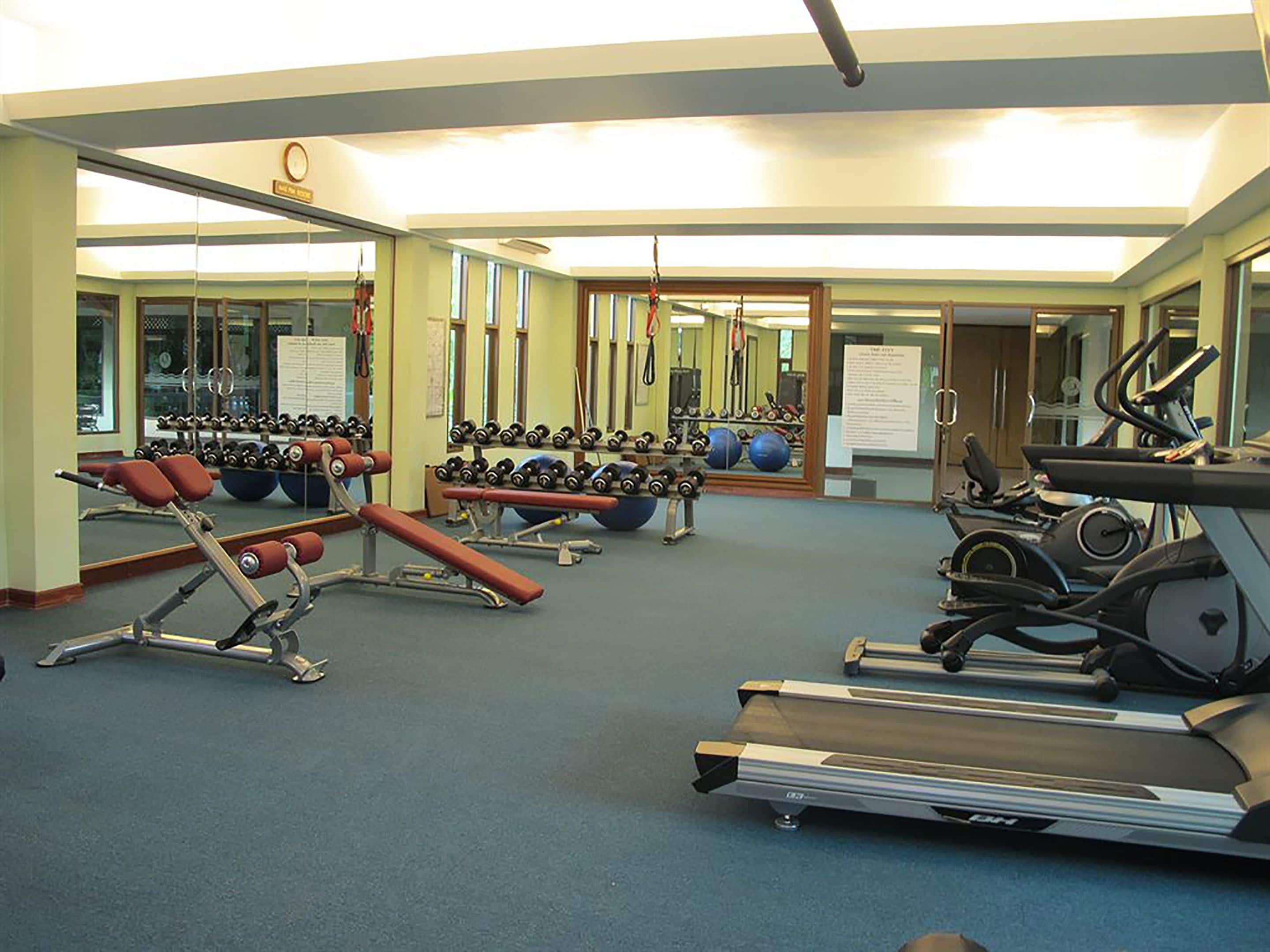 A gym with treadmills, weight machines, and free weights.