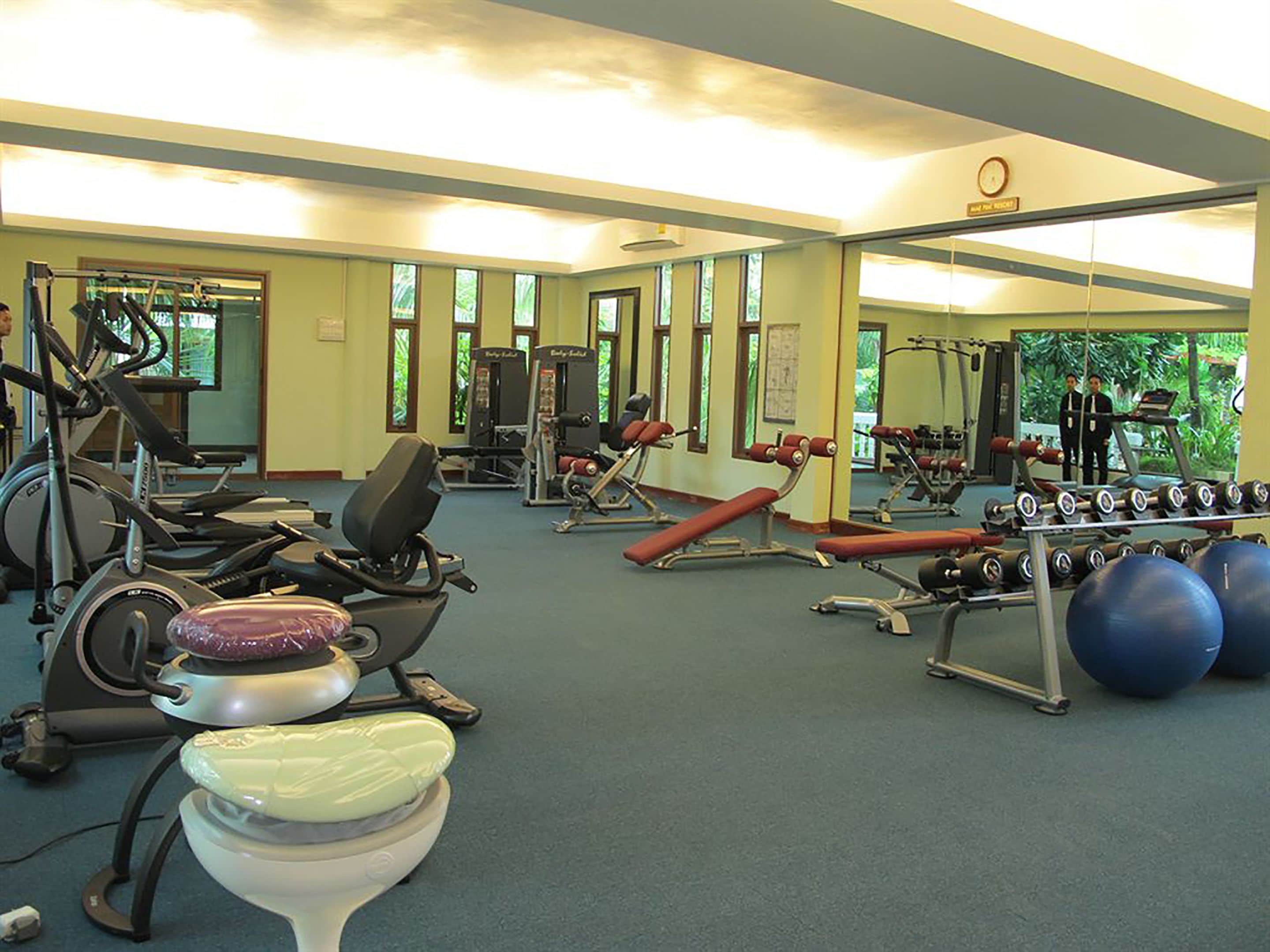 Ein Fitnessstudio mit Laufbändern, Krafttrainingsgeräten und Übungsbällen.