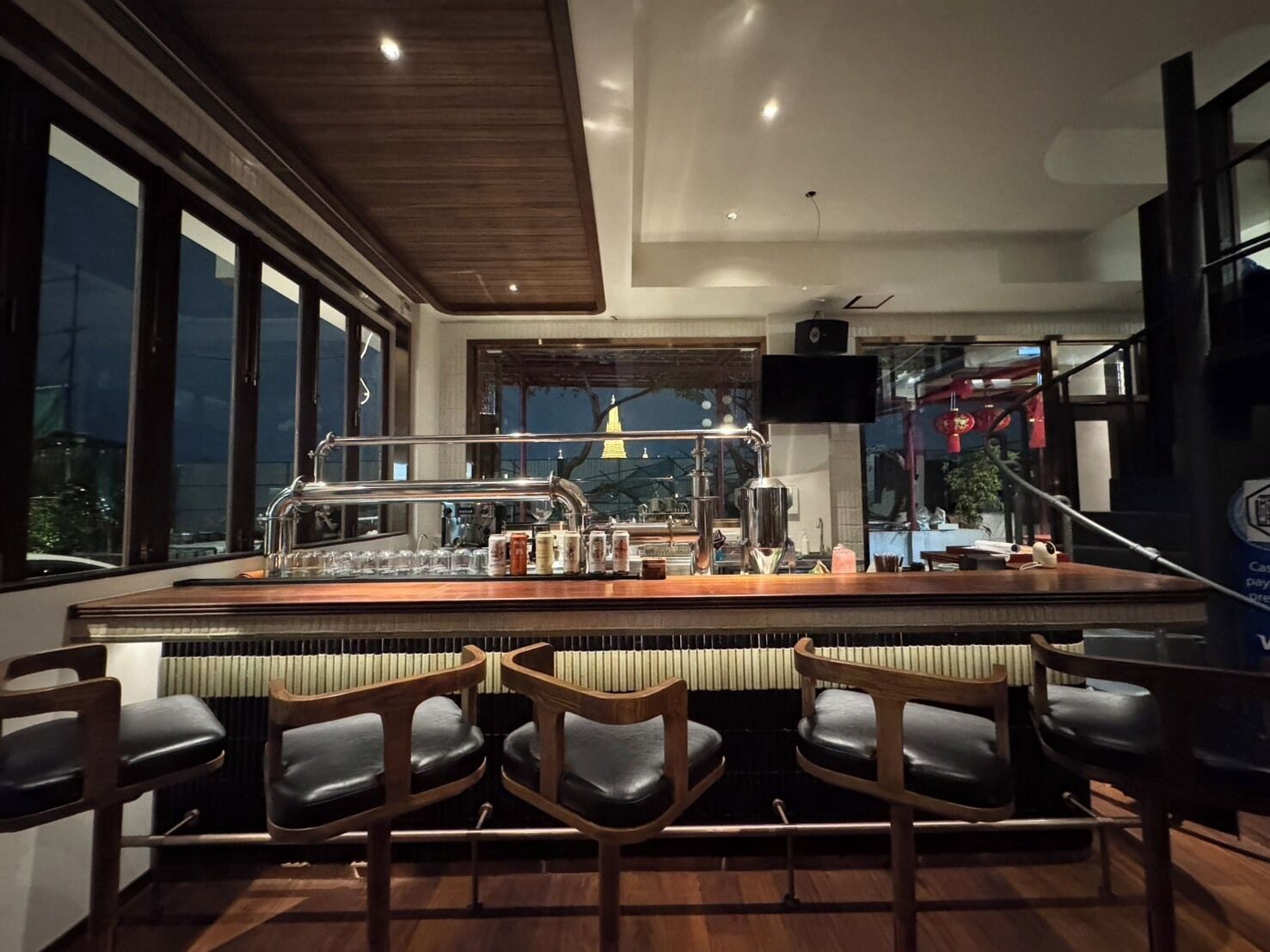 A bar area with a large island, bar stools, and a view of the cityscape.