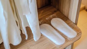 A wooden shelf with white fabric items and a pair of white pads.