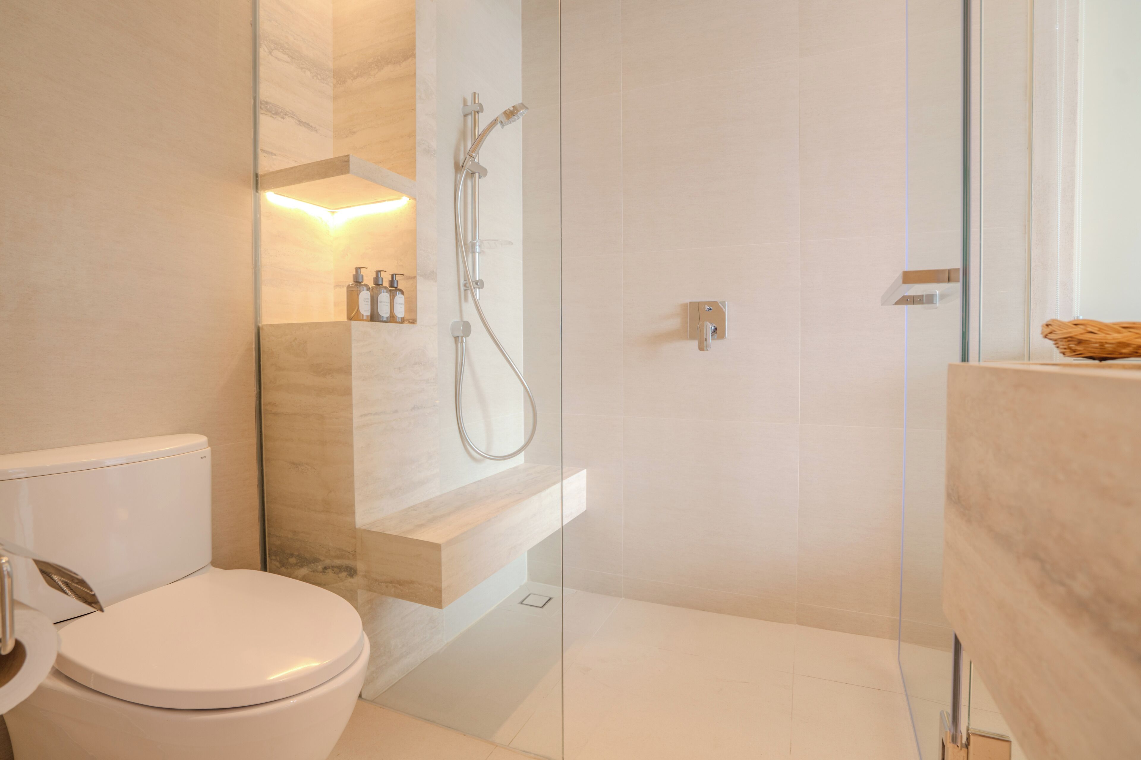 Une salle de bain moderne comprenant des toilettes, une douche à parois de verre et un meuble-lavabo avec un miroir.