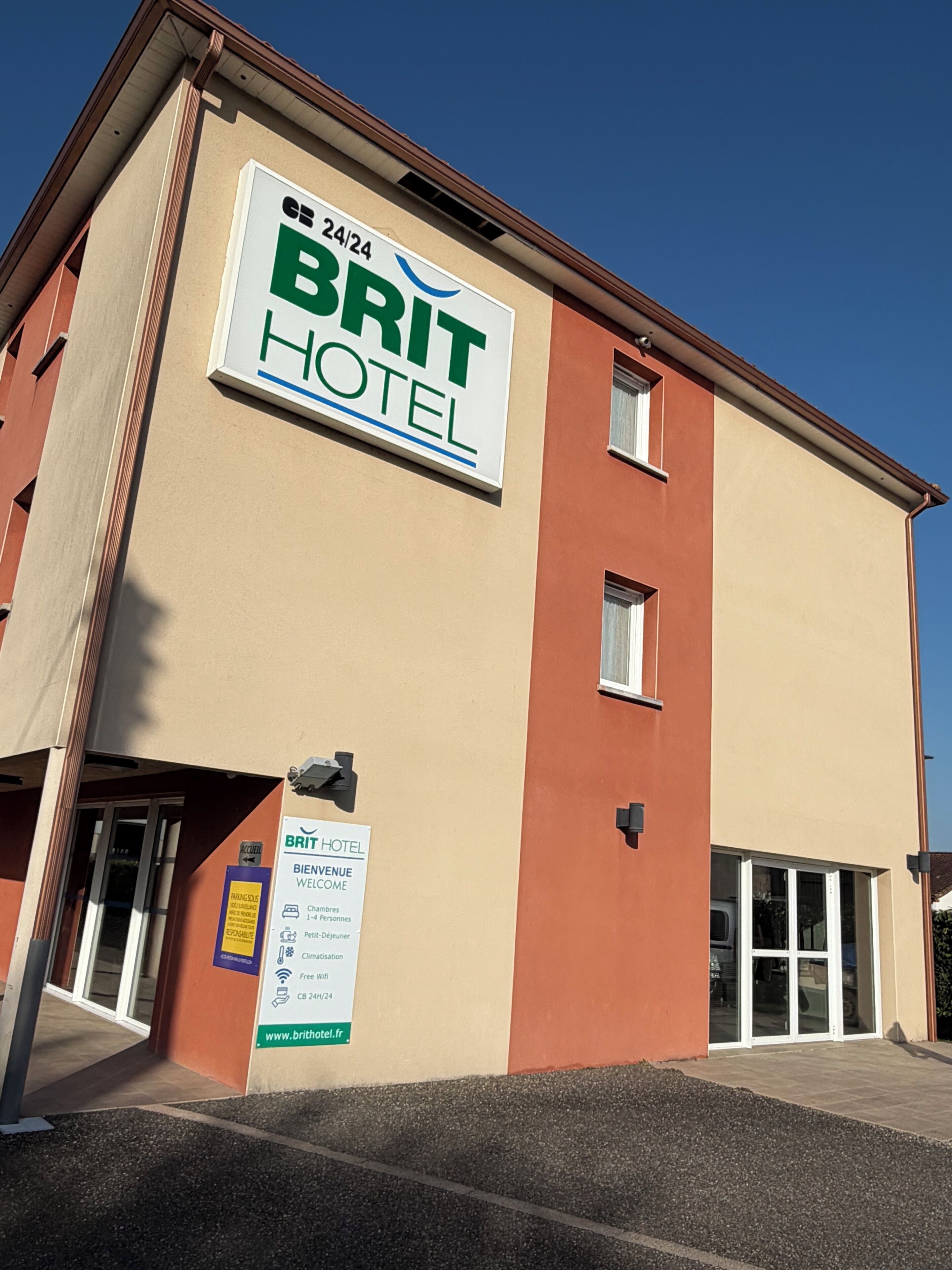 A BRIT HOTEL building with a sign indicating 24-hour service.