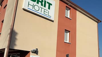 Edificio de BRIT HOTEL con un cartel que indica servicio las 24 horas.