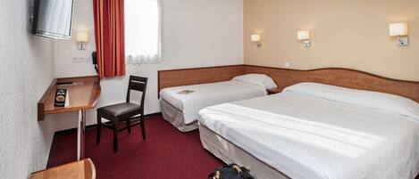 A hotel room with two beds, a desk with a chair, a TV, and a window with curtains.