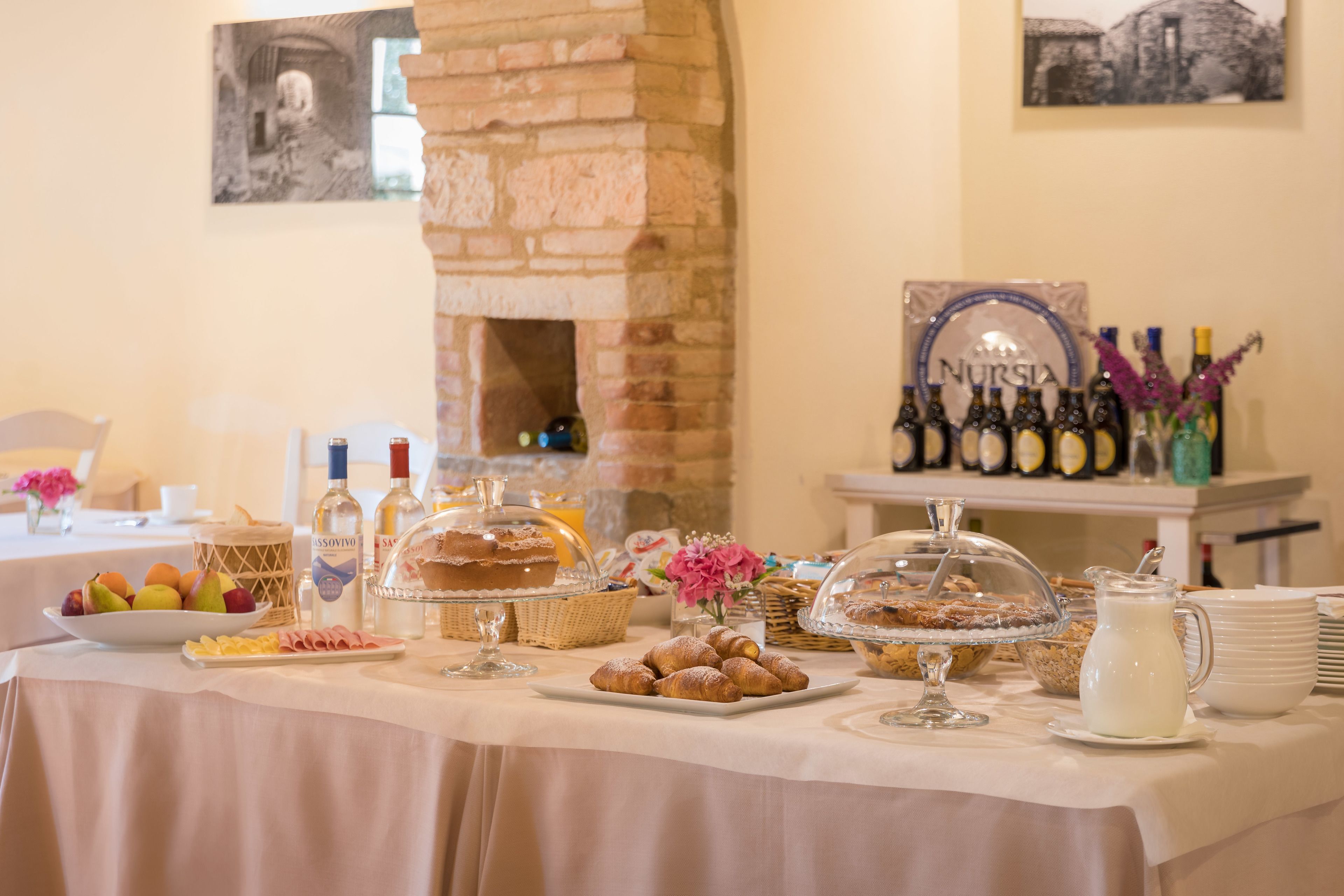 A breakfast buffet with various pastries, fruits, and beverages.