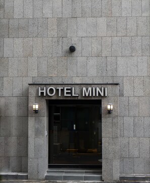 La façana d'un edifici amb el rètol "HOTEL MINI" sobre l'entrada.