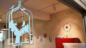 A room with a wall clock, framed artwork, and a hanging light fixture. - Popcorn Hostel Nampodong (Busan)