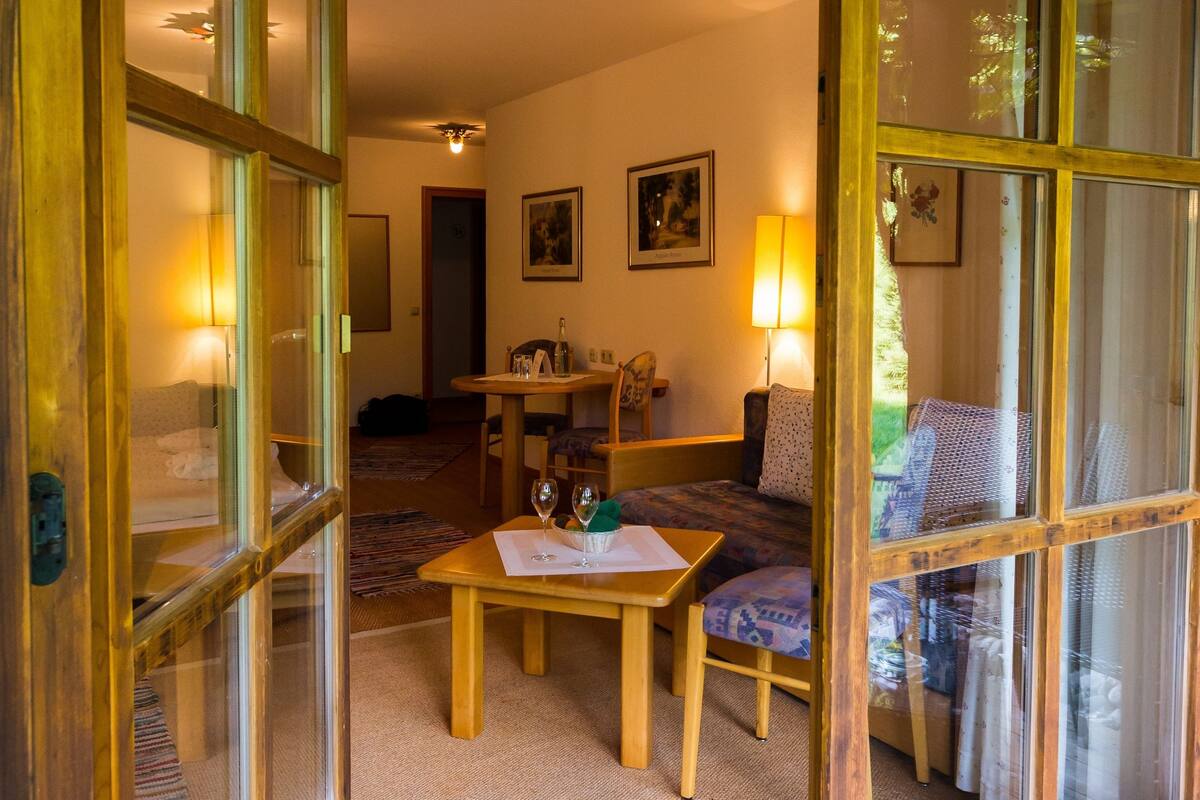 A traditional Japanese-style room with tatami flooring, a low wooden table, and a sofa.